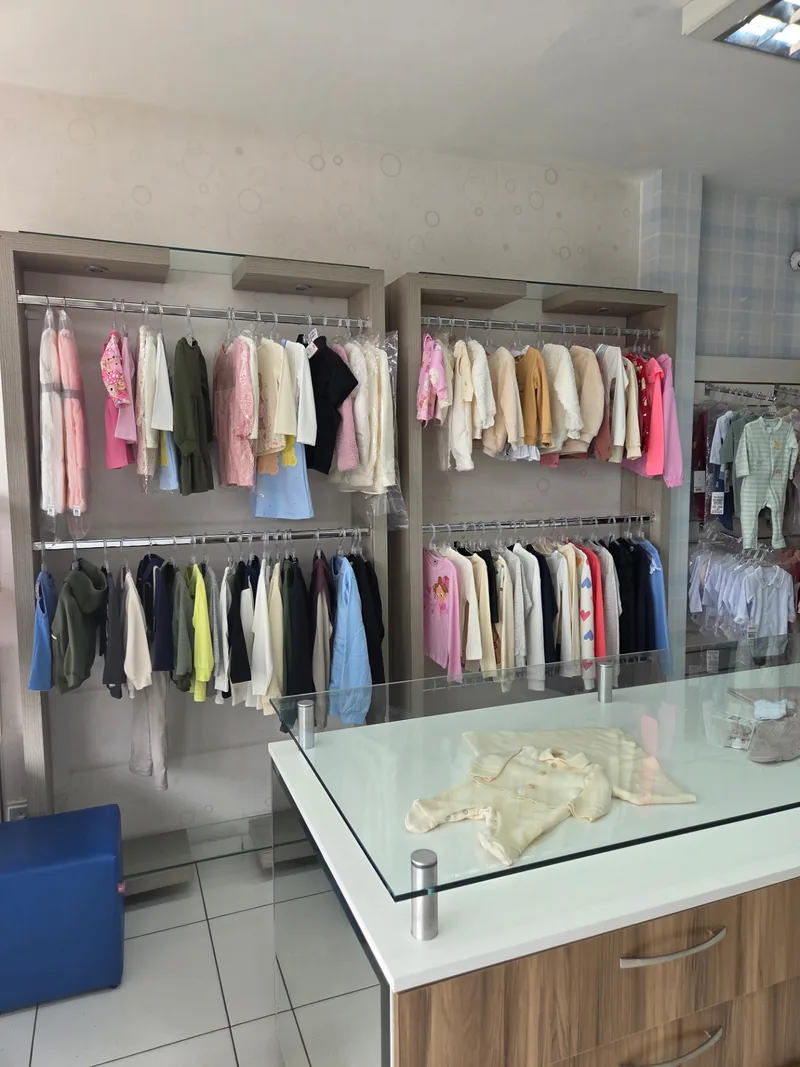 Ambiente da loja Bella Menina e Garoto Prodígio com araras de roupas infantis
